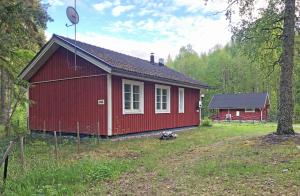 a red cabin in the middle of a forest at Riihilampi in Muurame