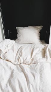 コペンハーゲンにあるApartmentInCopenhagen Apartment 308の白いシーツと枕が備わるベッド1台