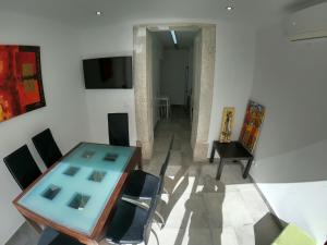 een eetkamer met een tafel en stoelen en een televisie bij Lisbon, renewed T1 apartment with pateo near Martires da Patria in Lissabon