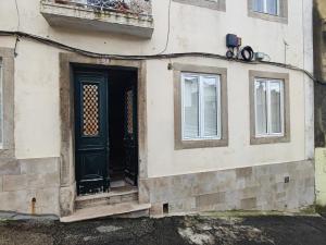 un edificio con una puerta negra y dos ventanas en Lisbon, renewed T1 apartment with pateo near Martires da Patria, en Lisboa