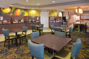 a restaurant with tables and chairs and a kitchen at Fairfield Inn Salt Lake City Layton in Layton