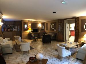 - un salon avec un canap&eacute;, des chaises et une table dans l'&eacute;tablissement The Originals City, H&ocirc;tel de la Balance, Montb&eacute;liard, &agrave; Montb&eacute;liard