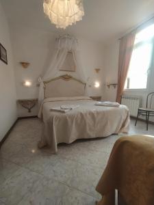Un dormitorio con una gran cama blanca con una lámpara de araña. en Cà Isabella, en Venecia 34 fotos más