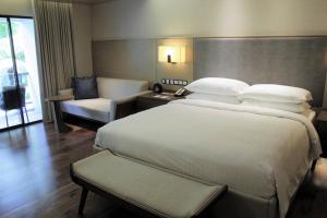 a hotel room with a large bed and a chair at Miri Marriott Resort & Spa in Miri