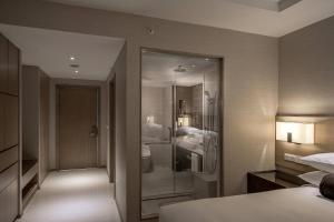 a hotel room with a shower and a bedroom at Miri Marriott Resort & Spa in Miri