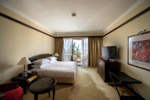 a hotel room with a bed and a television at Miri Marriott Resort & Spa in Miri