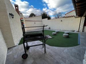 ein Grill in einem Innenhof mit einem grünen Hof in der Unterkunft Casa Aurora in Sanchidrián + 31 Fotos