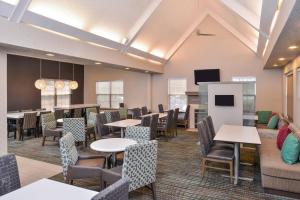 a dining room with tables and chairs and a tv at Residence Inn by Marriott Branson in Branson