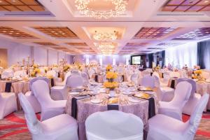 um salão de banquetes com mesas brancas e cadeiras brancas em Delta Hotels by Marriott Beausejour em Moncton