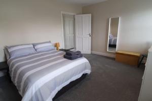 um quarto com uma cama grande e um espelho grande em Superb 4 Bed / 3 Bath Bungalow in Mitchelstown em Mitchelstown