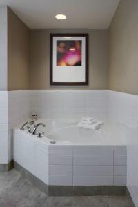 Una gran bañera blanca en el baño con una foto en Delta Hotels by Marriott Beausejour, en Moncton