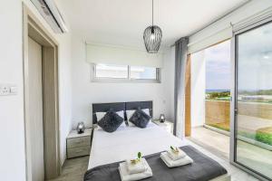 a bedroom with a bed and a large window at Villa Alasia in Paralimni