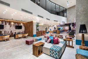 a lobby with a couch and tables and a bar at Aloft Tulum in Tulum