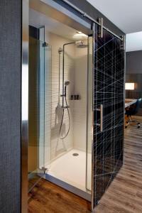 a shower in a bathroom with a glass door at AC Hotel by Marriott Seattle Bellevue/Downtown in Bellevue
