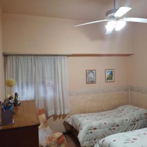 una camera con 2 letti e un ventilatore a soffitto di chalet de tata a Tandil