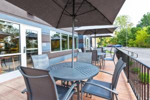 a table and chairs with an umbrella on a balcony at Fairfield Inn & Suites by Marriott Goshen in Goshen