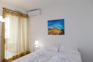um quarto com uma cama branca e uma janela em Charming T2 "Antibes Les Pins 3" air-conditioned with parking and swimming em Antibes