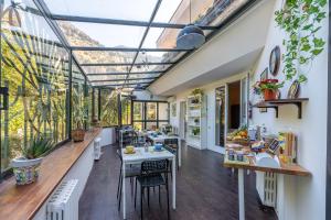 a conservatory with tables and chairs and windows at Bouganville Home Mondello in Mondello