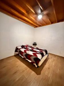a bed in a room with a white wall at Bonito departamento rustico in Rosarito