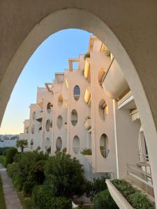 een uitzicht op een gebouw door een boog bij appartement vue mer résidence les terrasses de la mer in La Grande-Motte