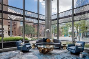 eine Lobby mit einem Sofa, Stühlen und Fenstern in der Unterkunft JW Marriott Grand Rapids in Grand Rapids