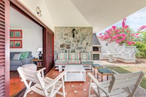 a patio with chairs and a table and a couch at Chalet Umbelina con jardin y vista al mar in Palm-mar