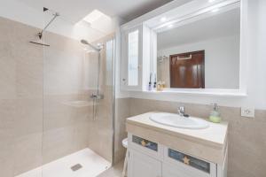 a white bathroom with a sink and a shower at Chalet Umbelina con jardin y vista al mar in Palm-mar