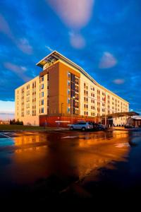 un grande edificio giallo con auto parcheggiate in un parcheggio di Aloft Mount Laurel a Mount Laurel