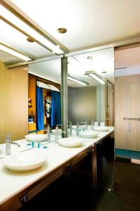 a bathroom with a row of sinks and mirrors at Aloft Mount Laurel in Mount Laurel