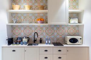 a kitchen counter with a sink and a microwave at Samaritana Suites in Palma de Mallorca