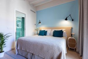 a bedroom with a bed with blue walls and a window at Samaritana Suites in Palma de Mallorca