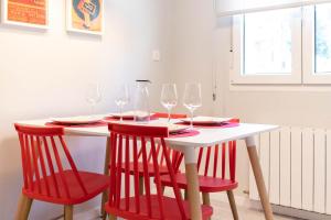 a white table with red chairs and wine glasses at Bilbao Old Town VI by Aston Rentals in Bilbao