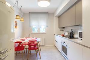 a kitchen with a table and red chairs in a kitchen at Bilbao Old Town VI by Aston Rentals in Bilbao