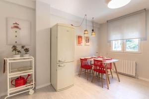 a kitchen and dining room with a table and a refrigerator at Bilbao Old Town VI by Aston Rentals in Bilbao