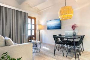 a living room with a table with a laptop on it at Samaritana Suites in Palma de Mallorca