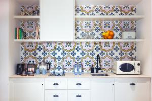 a kitchen with white cabinets and blue and white tiles at Samaritana Suites in Palma de Mallorca
