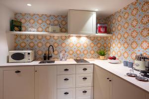 a kitchen with a sink and a microwave at Samaritana Suites in Palma de Mallorca
