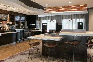 a lobby with a bar with stools at Courtyard by Marriott Omaha Bellevue at Beardmore Event Center in Bellevue