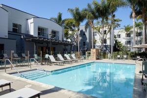 a swimming pool at a hotel with chairs and a building at Residence Inn San Diego Carlsbad in Carlsbad