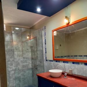 y baño con lavabo y ducha con espejo. en Casa de campo en Belén