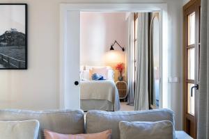 a room with a bed and a room with chairs at Samaritana Suites in Palma de Mallorca
