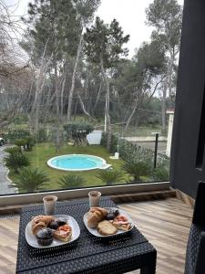 2 platos de repostería en una mesa con vistas a la piscina en Luxury B&B La Riserva Dannunziana, en Pescara