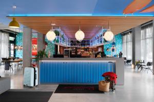 a lobby with a blue wall in a restaurant at Moxy Sophia Antipolis in Biot