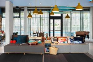 a living room with two couches and a table at Moxy Sophia Antipolis in Biot