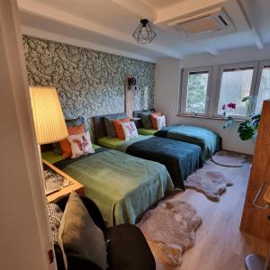 Habitación con 3 camas y sofá en Exklusive Ferienwohnung Hattorfer Teiche, en Wolfsburg