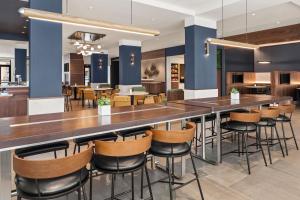 a large bar in a restaurant with stools at Courtyard by Marriott Owatonna Downtown in Owatonna