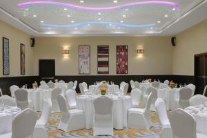 賈贊的住宿－吉贊萬怡酒店，一间会议室,配有白色的桌子和白色的椅子