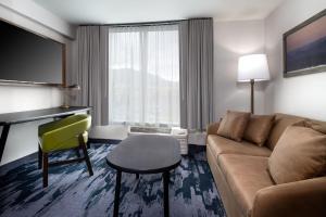 un soggiorno con divano e sedia in una camera d'albergo di Fairfield Inn & Suites Boulder a Boulder