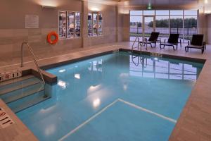 a swimming pool with blue water in a building at Courtyard by Marriott Saskatoon Airport in Saskatoon