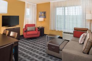 a living room with a couch and a chair and a television at TownePlace Suites by Marriott New Hartford in New Hartford